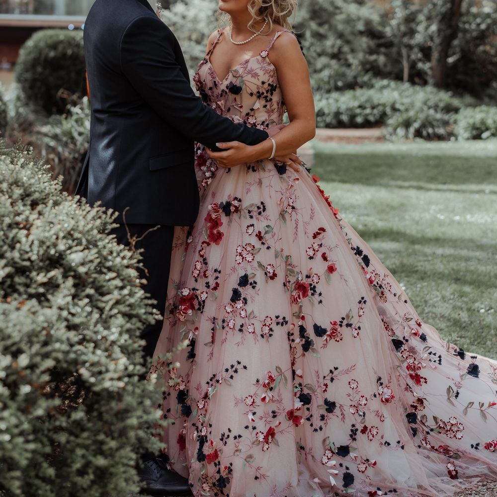 Bride & groom look lovingly at one another on their wedding day as bride wears floral appliqué wedding gown