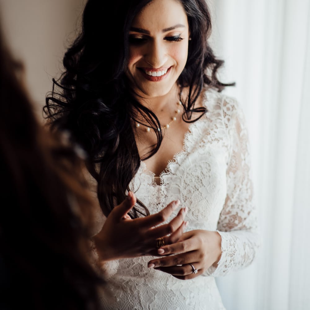 Bride wears her dark hair in full and loose curls