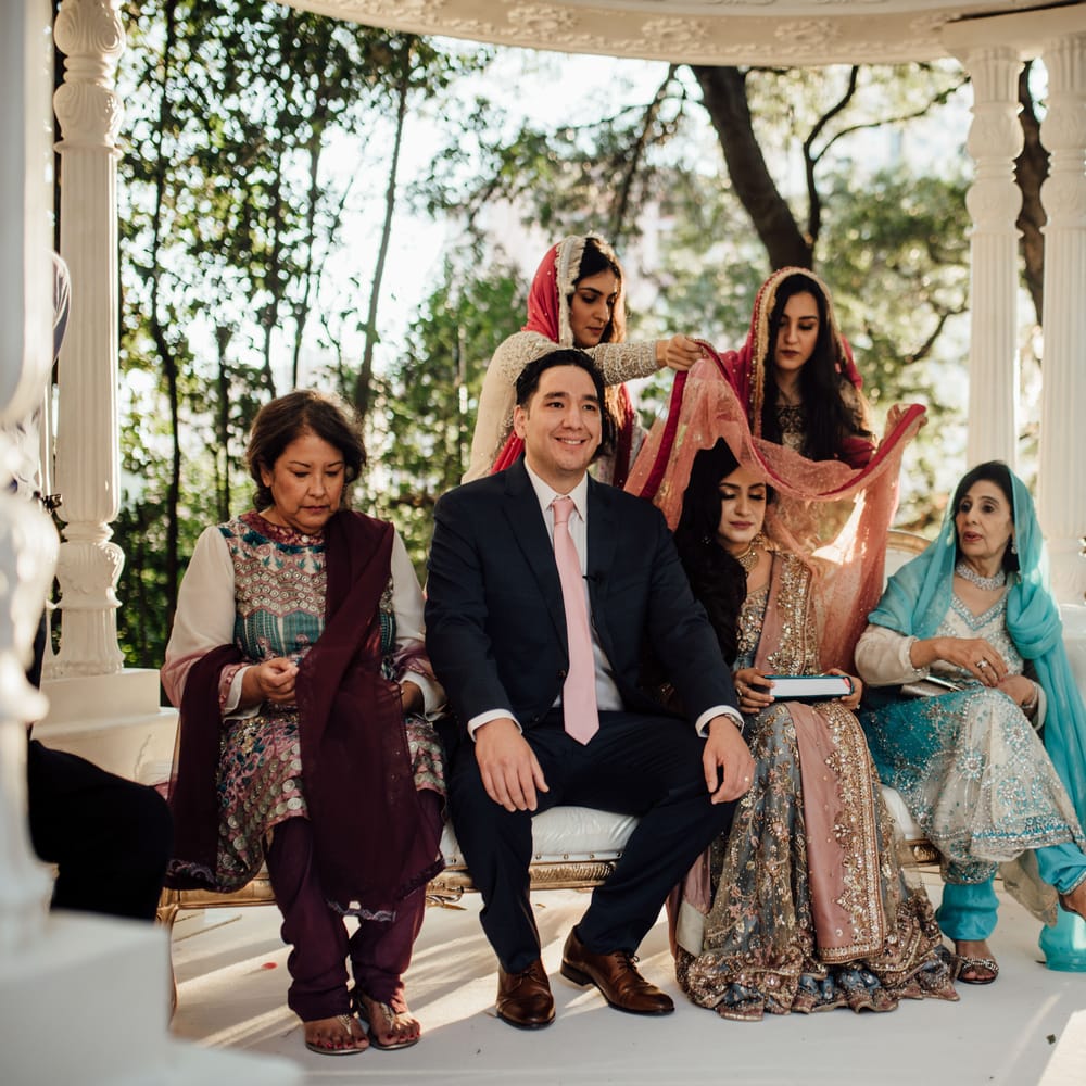 Brides veil is lifted during traditional wedding ceremony outdoors