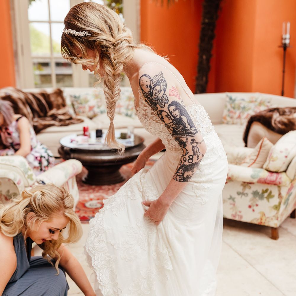 Bride has her Dr Martens put on by wedding guest on the day of her wedding