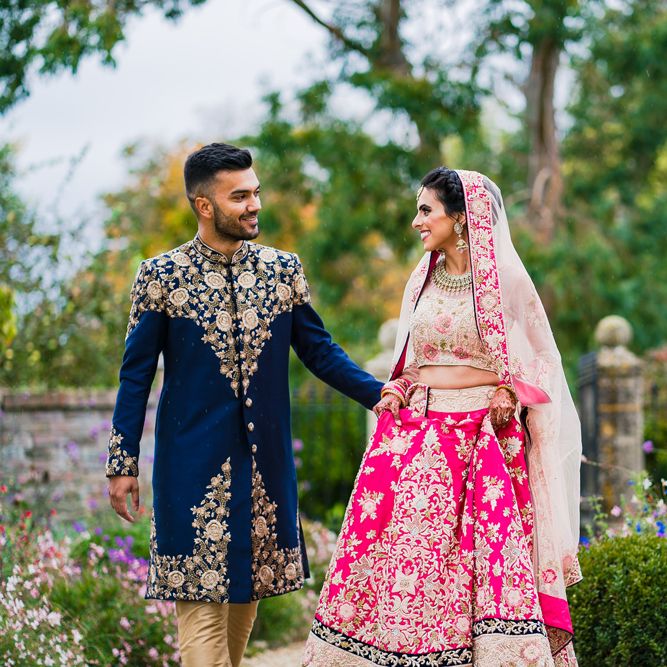 Brightly coloured Hindu fusion wedding at Elmore court with bride in a pink wedding dress and groom in a navy blue and gold suit