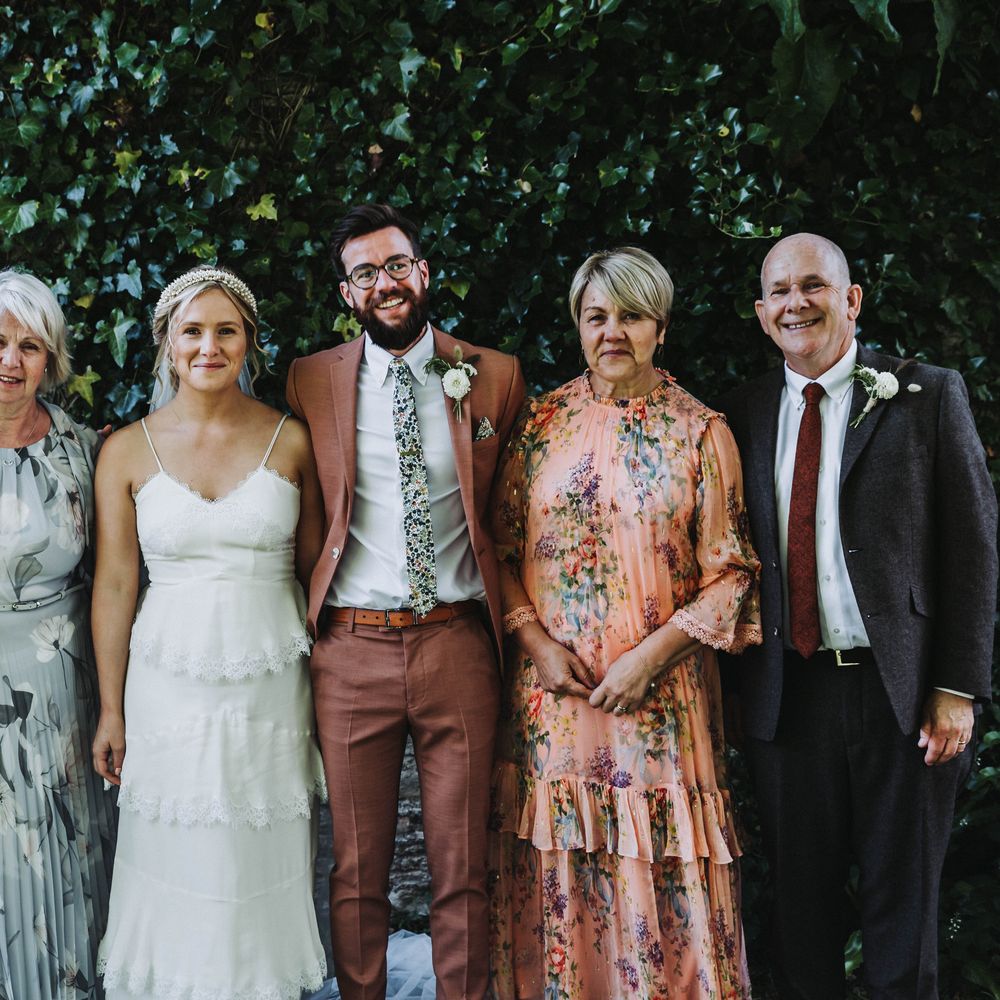 Wedding guests gather together for family photos after wedding ceremony in Cornwall