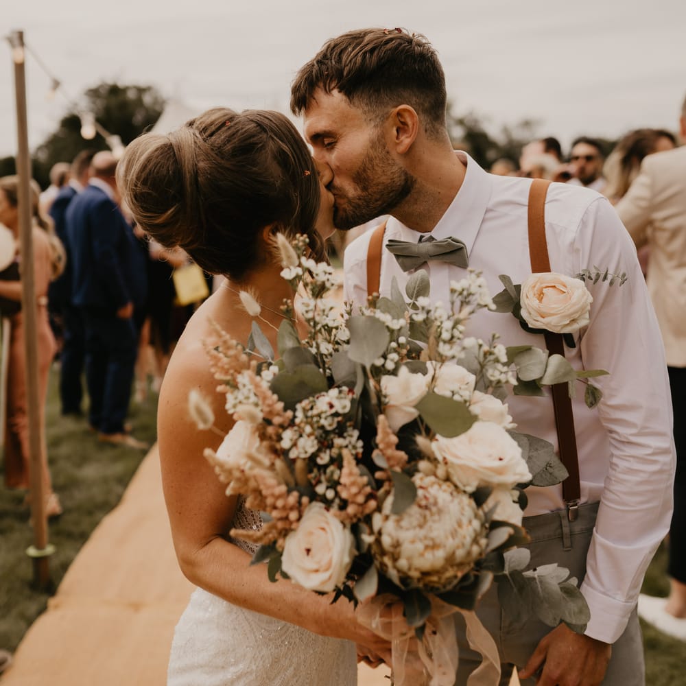 Bride & groom kiss on their wedding day outdoors  | Mark Bamforth Photography