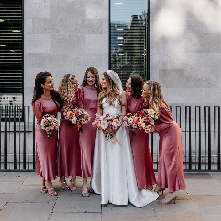 Bridal party in Ghost pink satin bridesmaid dresses with long sleeves and the bride in a Karen Willis Holmes wedding dress 