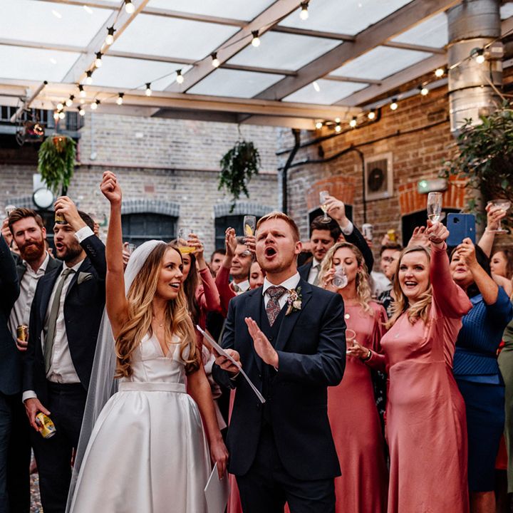 Wedding speeches at The Loft Studios with groom in a navy wool suit and bride in a princess wedding dress