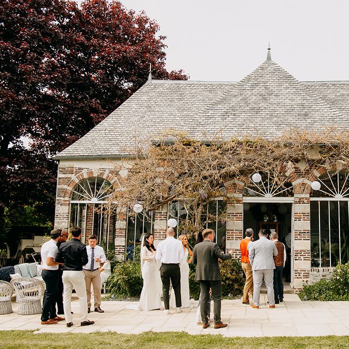 Wedding guests socialise outside of the venue 