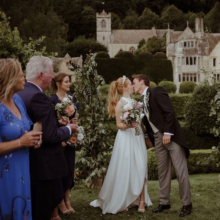 Bride and groom share a kiss after their handfasting wedding ceremony 