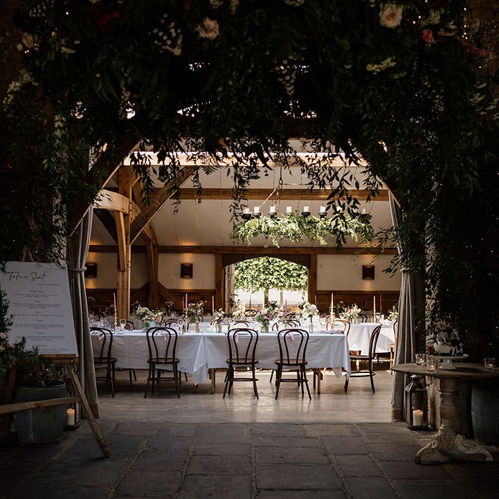 Entrance to the reception room at Cripps Barn wedding venue with lots of greenery and pink decor 