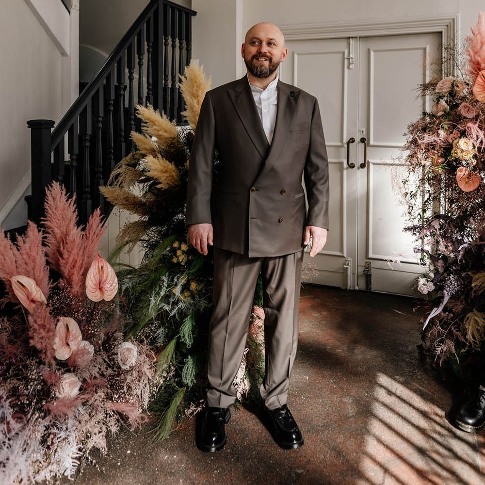 Groom in a white open collar shirt and double breasted jacket at styling London wedding 