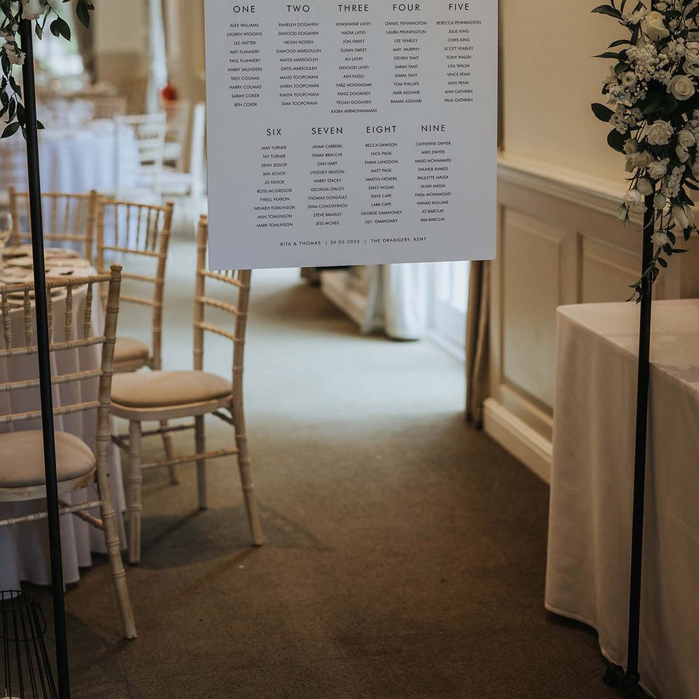 Minimal black and white wedding seating chart decorated with white roses 