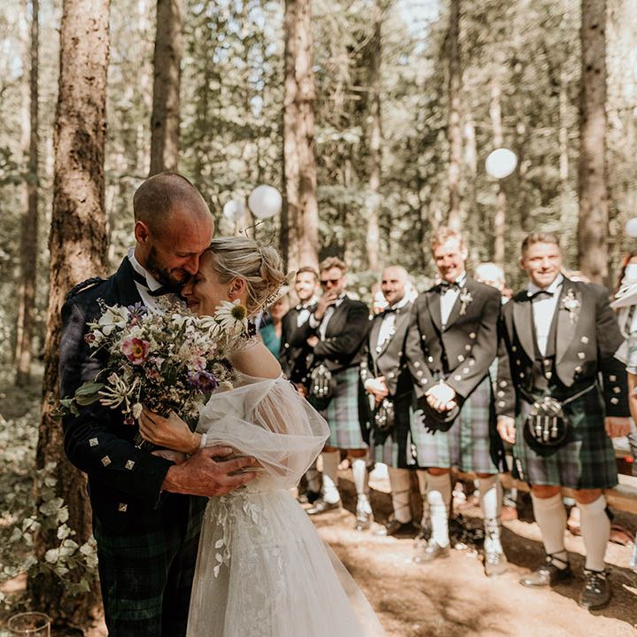 The bride and groom have an emotional embrace together at the altar for their humanist outdoor woodland wedding 