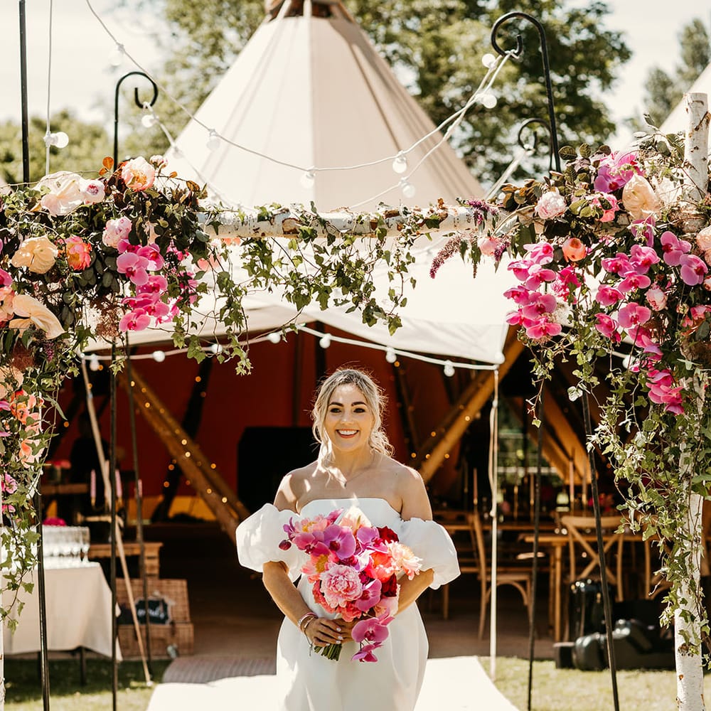 Bride in off the shoulder wedding dress with pink wedding bouquet 