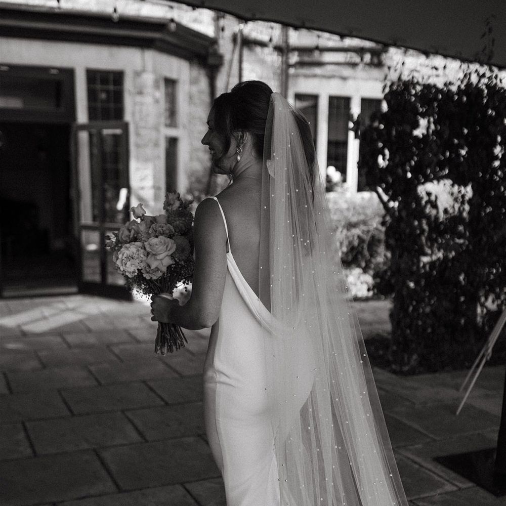 Bride wearing delicate pearl veil and open back satin gown by Made With Love 