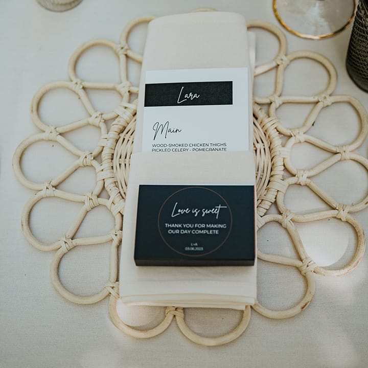Black and white wedding menu with wicker placemat and half and half coloured cutlery 