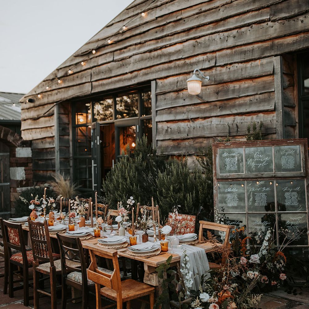 Outdoor wedding tablescape with window table plan sign and autumnal tablescape with brown taper candles 