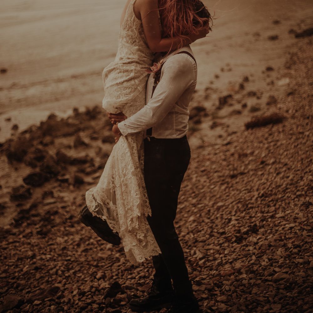 Bride and groom kissing at beach elopement