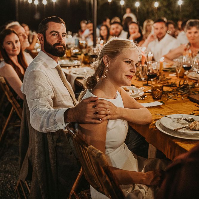 Bride and groom holding hands during outdoor wedding reception 