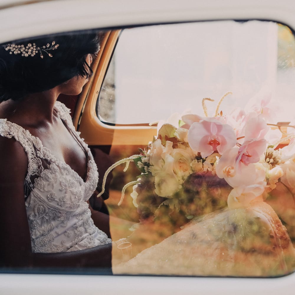 Bride sat in car on the way to her summer wedding in Italy holding bridal bouquet 