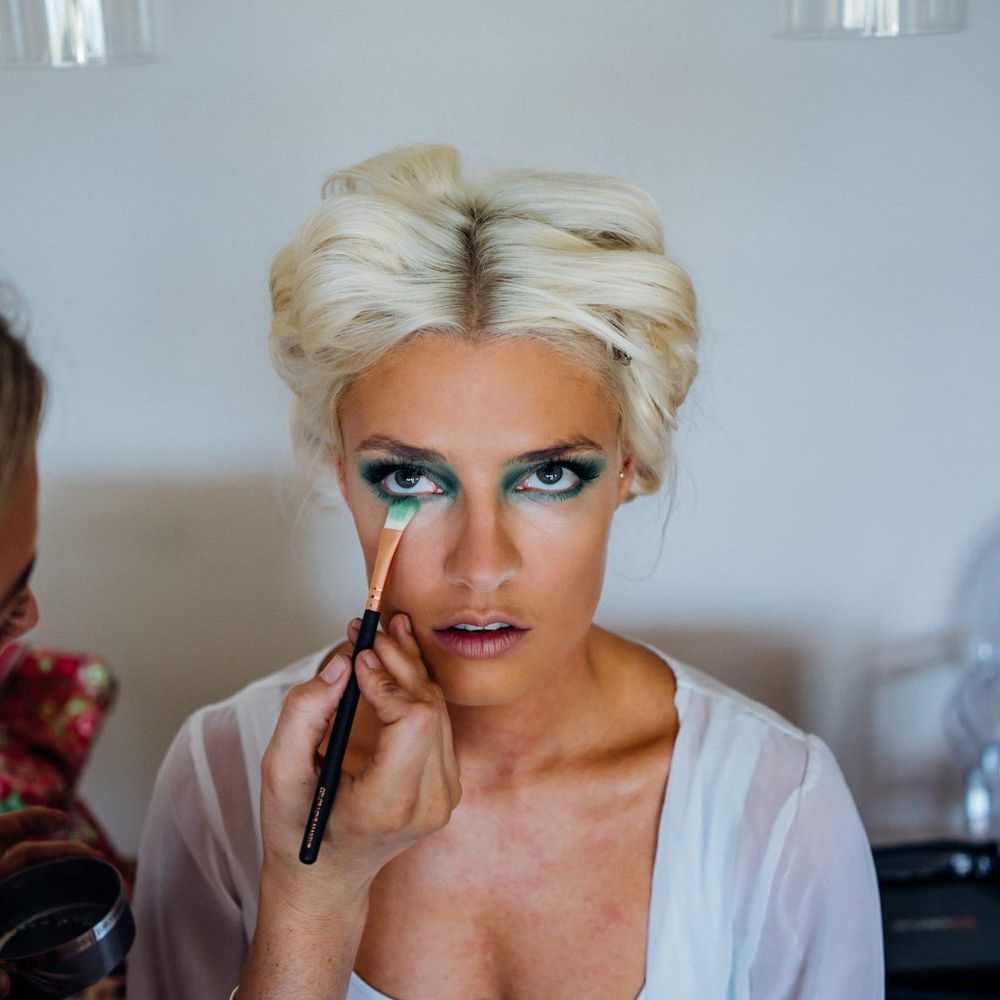 Bride gets her makeup done with dramatic eyes
