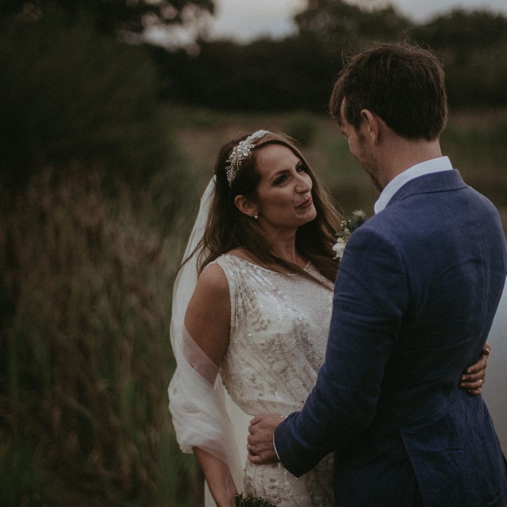 Bride looks lovingly at groom outdoors on their wedding day