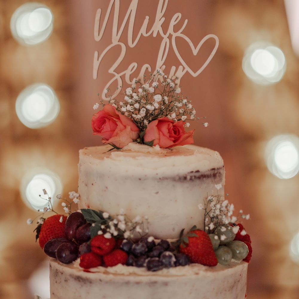 3 tier wedding cake with naked frosting and fruit decoration 