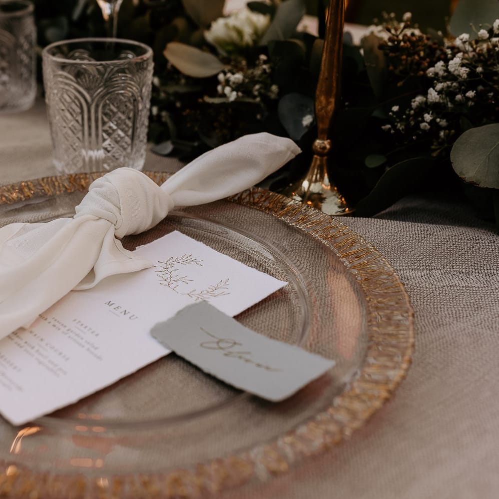 gold rimmed glass charger plate with menu and place cards on the day wedding stationery 