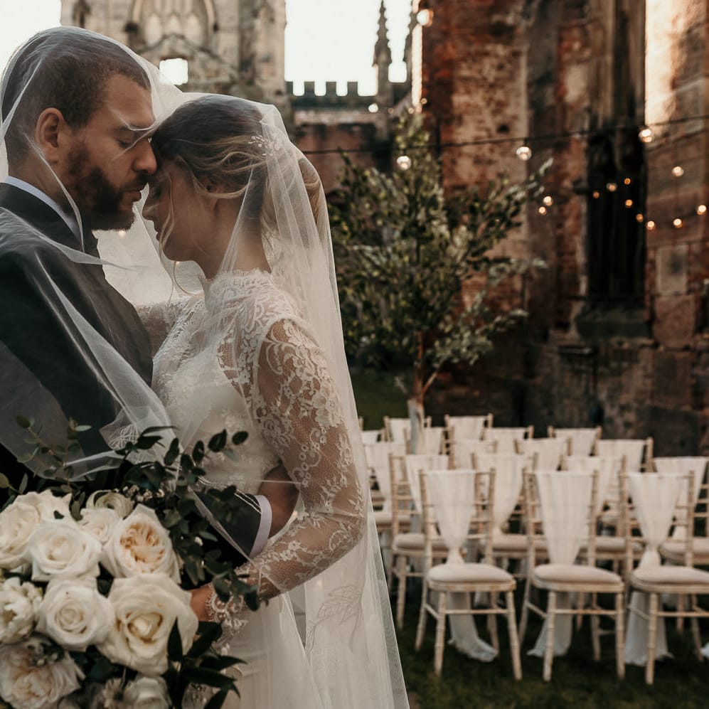 Intimate bride and groom portrait at St Luke's in Liverpool with festoon lights and tree decoration 