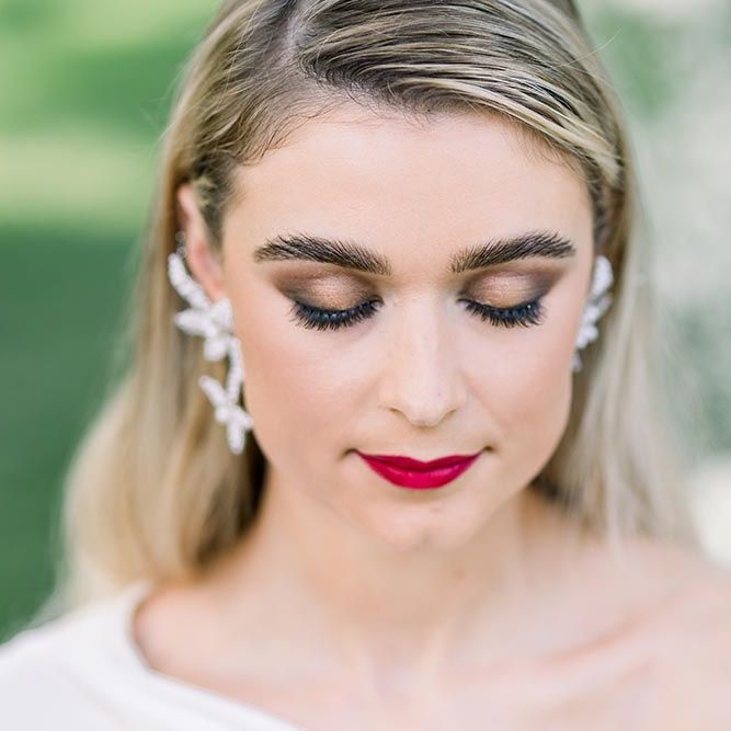 Bronze smokey eye makeup, defined eyebrows and red lipstick for stylish bride 