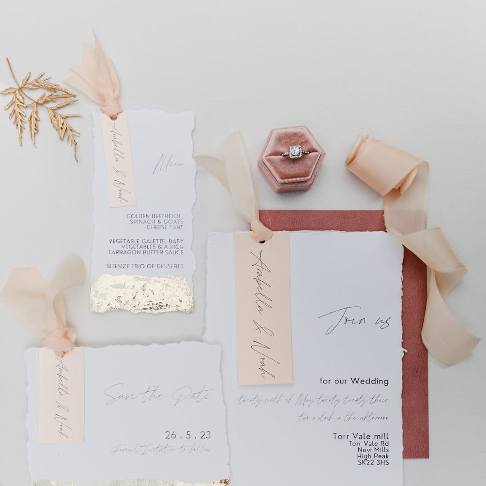 Flat lay of an elegant wedding stationery suite with gold and pink design