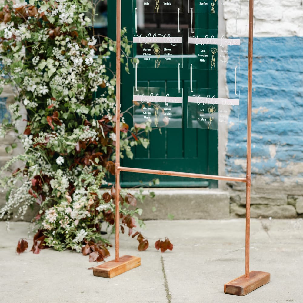 Copper frame seating chart with hanging acrylic signs