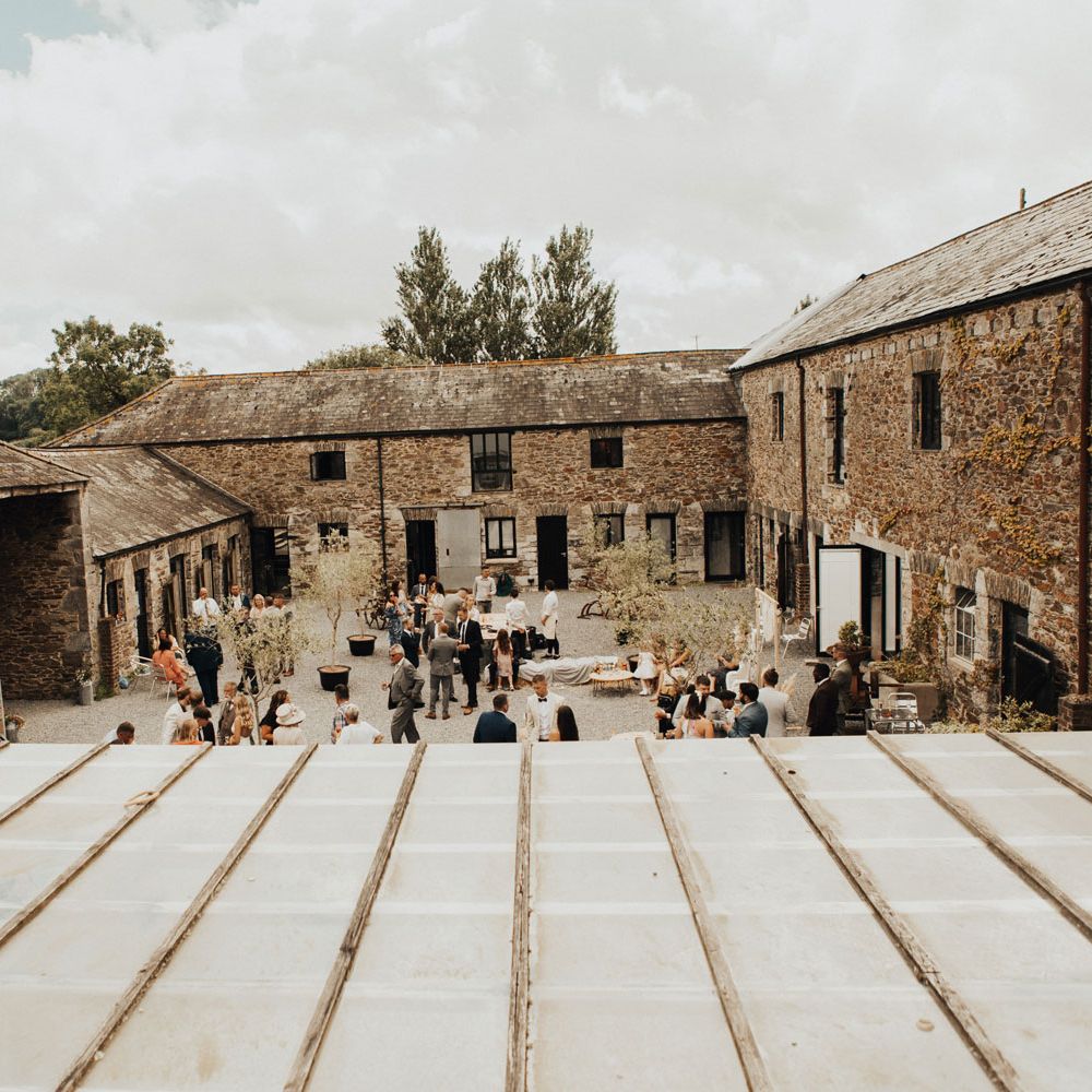 Courtyard at Anran Devon filled with wedding guests and boho decor for summer wedding