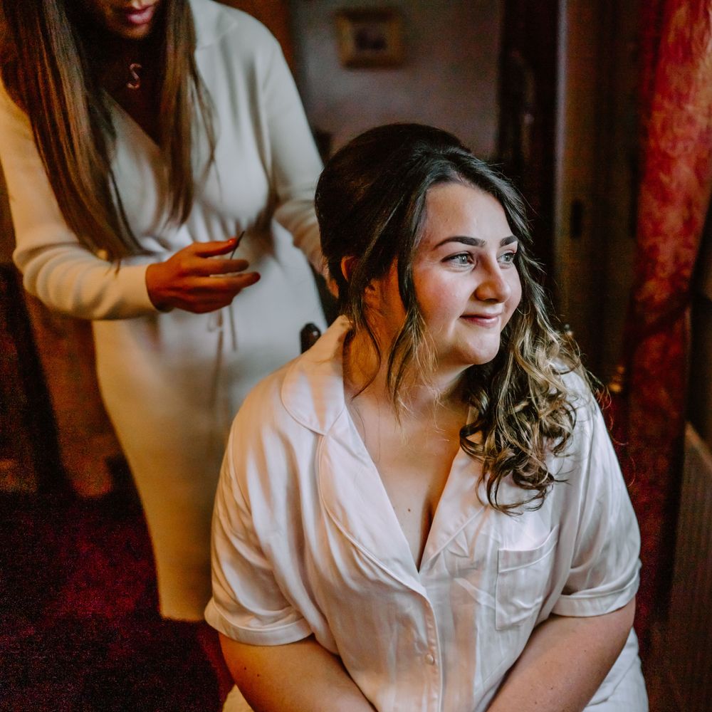 Bride has her dark hair curled on the morning of her wedding day
