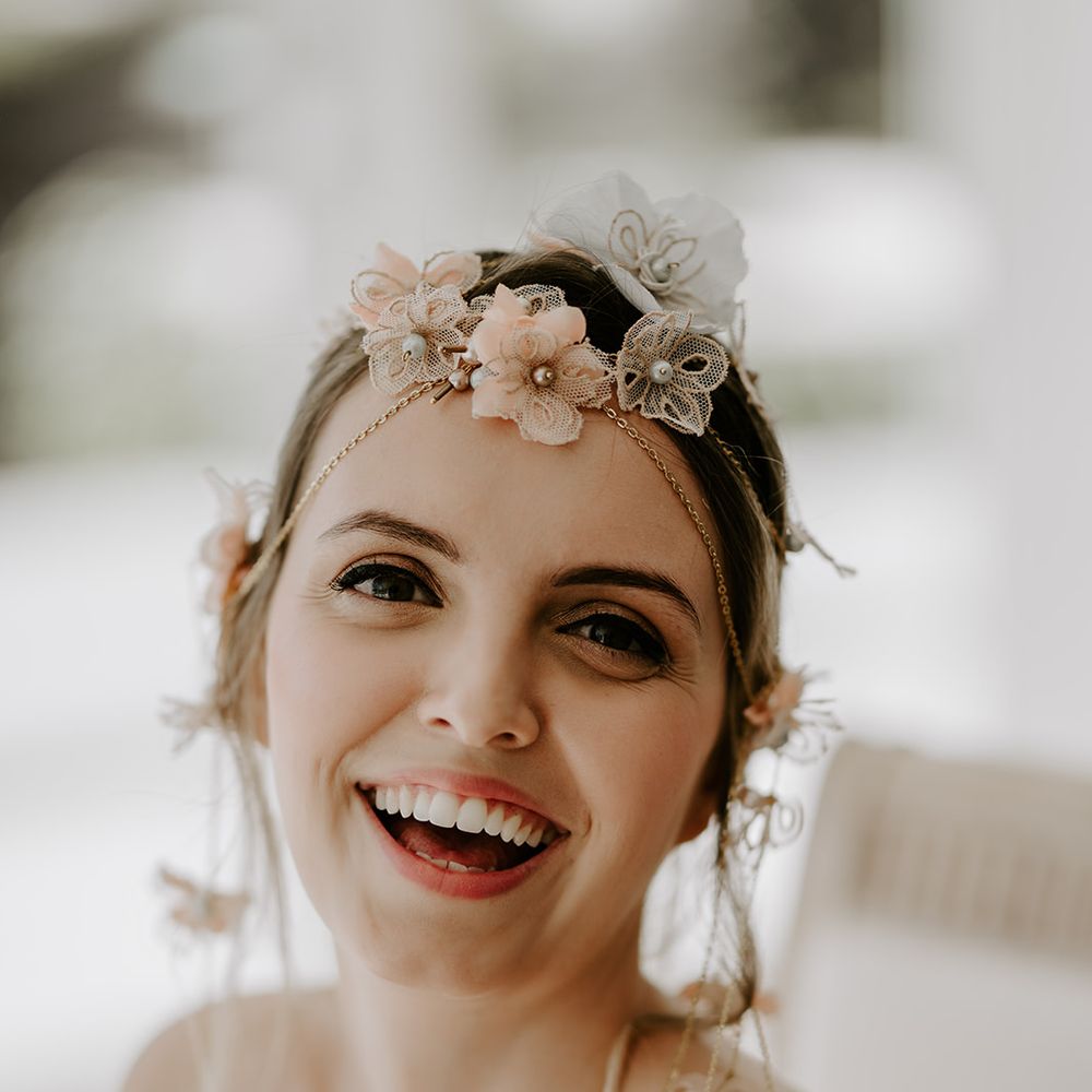 Beautiful bride with brown eyeshadow and pink lipstick wearing a delicate headdress 