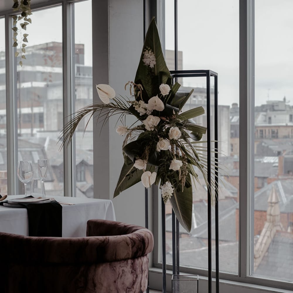 Tropical wedding flower arrangement with white anthuriums and palms leaves at Manchester Hall 