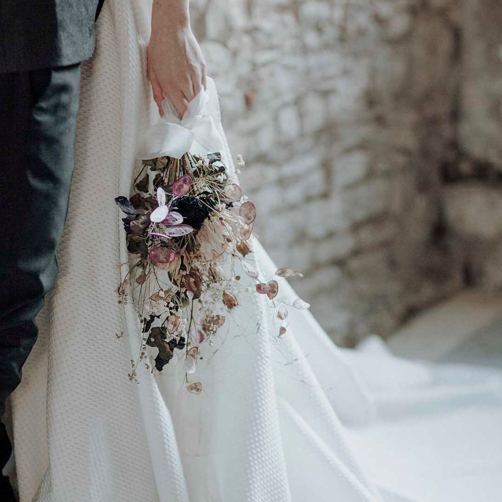 Bride in a princess wedding dress with waffle design holding a minimalist dried flower wedding bouquet 