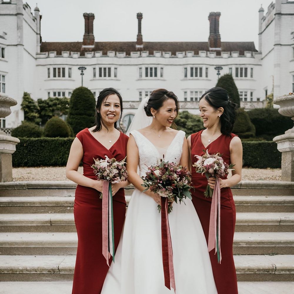 Bride in A Line gown with bridesmaids in burgundy dresses