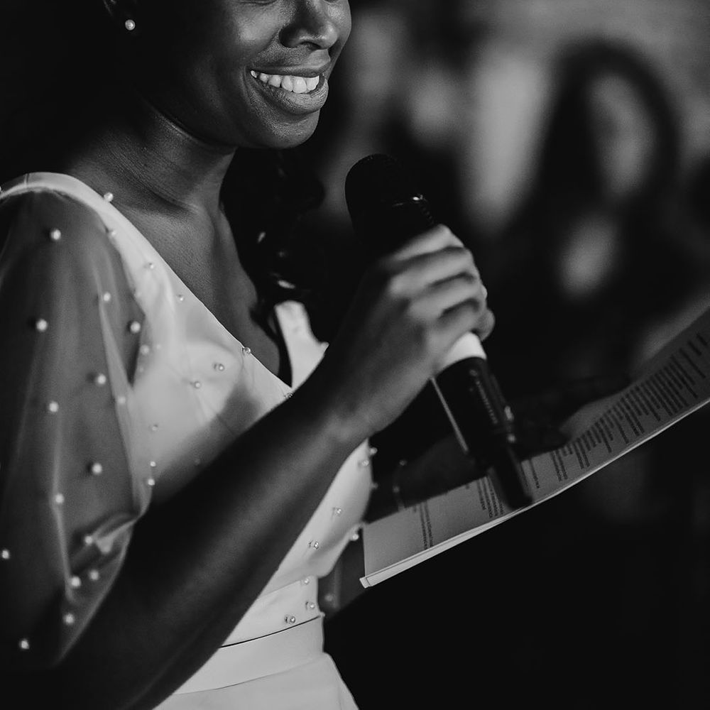 Black bride in a pearl top giving her brides' wedding speech 