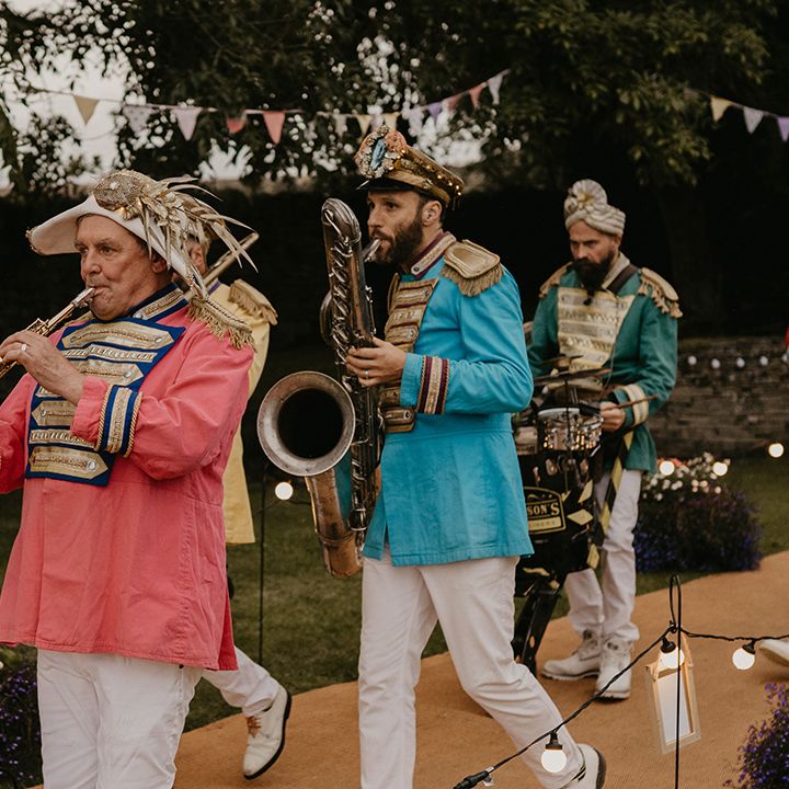 Live wedding band in colourful outfits and different hats play their instruments