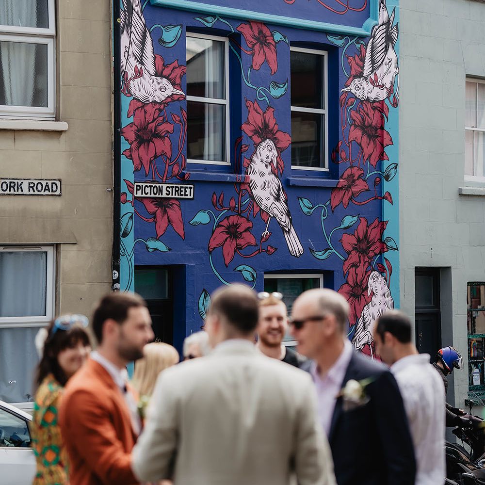 Colourful exterior of building in Bristol as wedding guests gather outdoors 