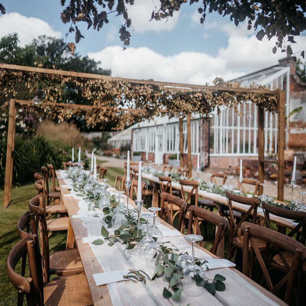 Neutral themed wedding tablescape with sheer white table runner and foliage decorations at Wasing Park