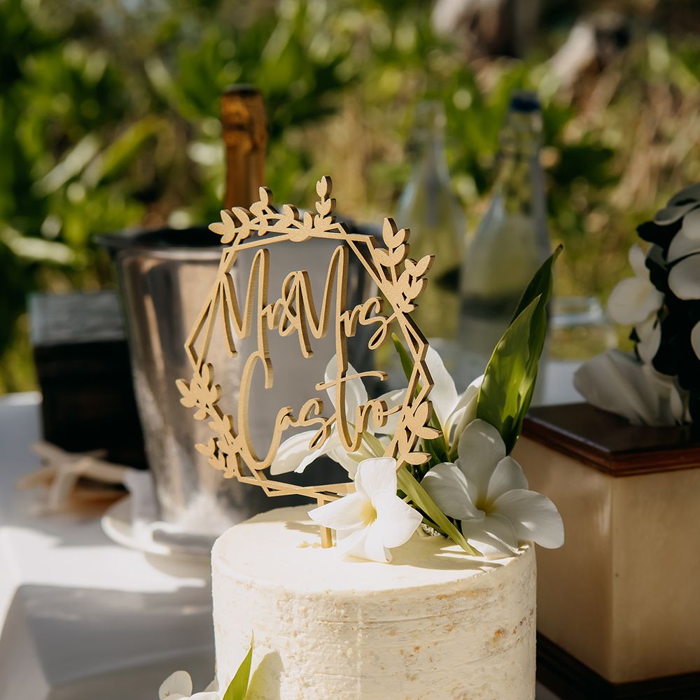 Single tier buttercream wedding cake with personalised gold laser cut wedding topper and tropical flower decorations