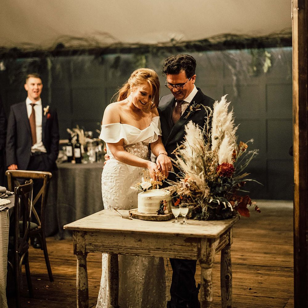 Bride & groom cut naked wedding cake with DIY cake topper 