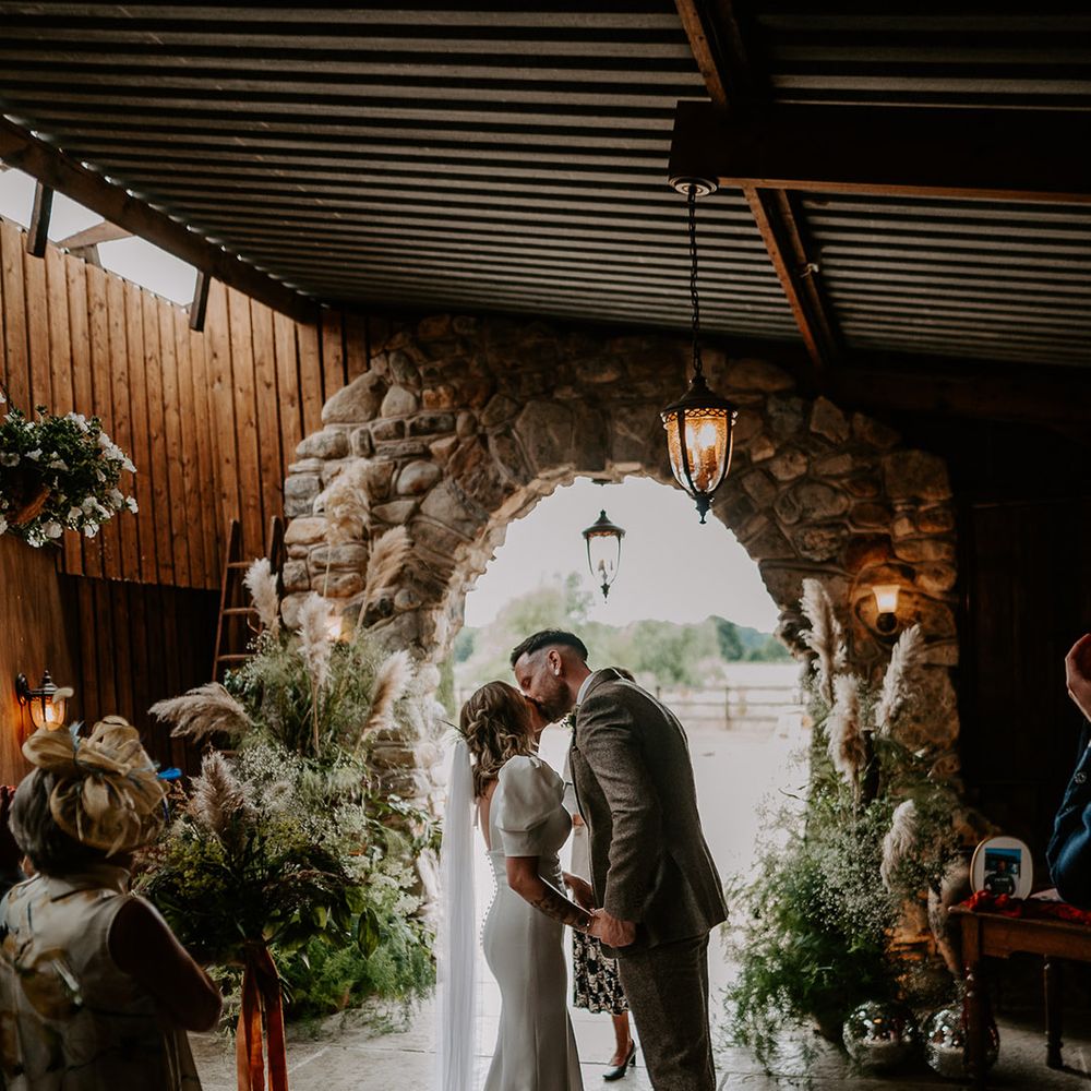 First kiss between the bride and groom at Willow Marsh Farm in Loughborough wedding 