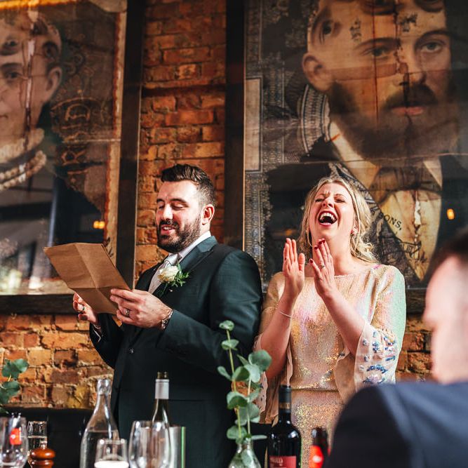 Bride & groom laugh together during speeches at reception