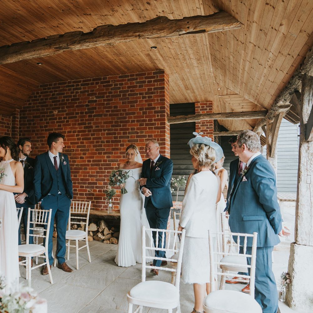 Bride walks down the aisle with her father surrounded by wedding party
