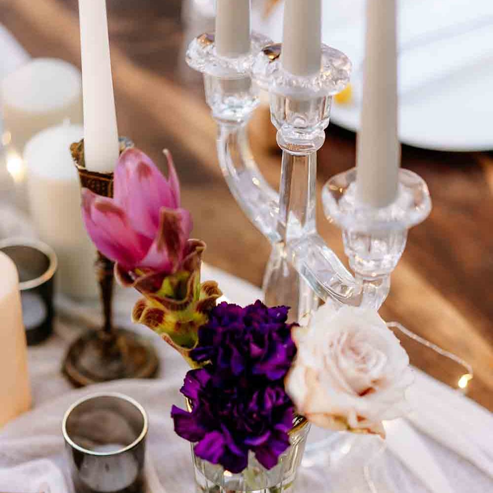Pink and purple wedding flower table decor with candles