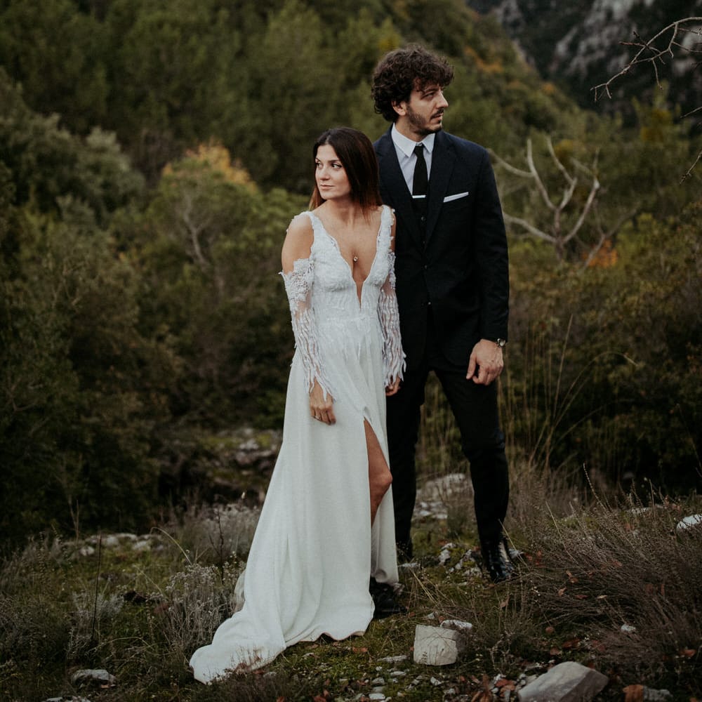 The bride and groom in front of a forest and hillscape