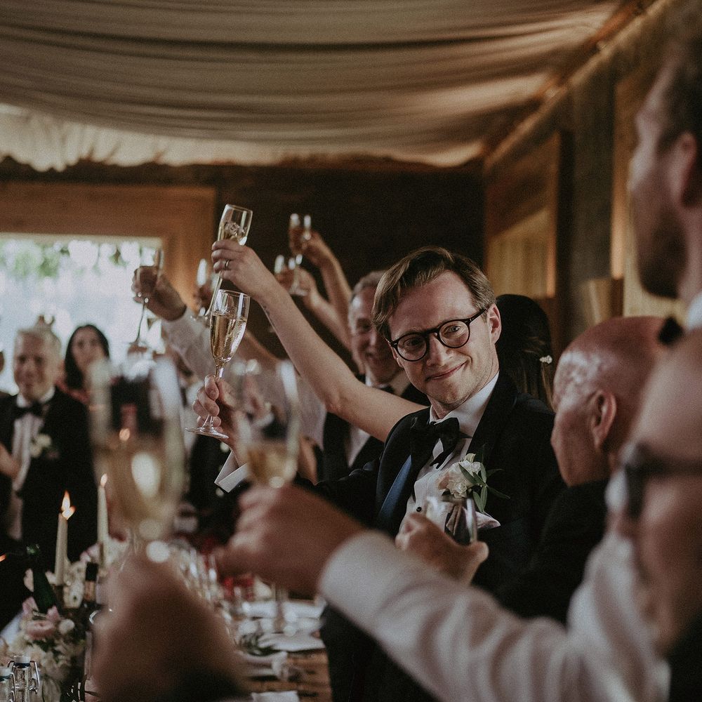 Wedding reception party raise their glasses at Elmore Court for classic wedding