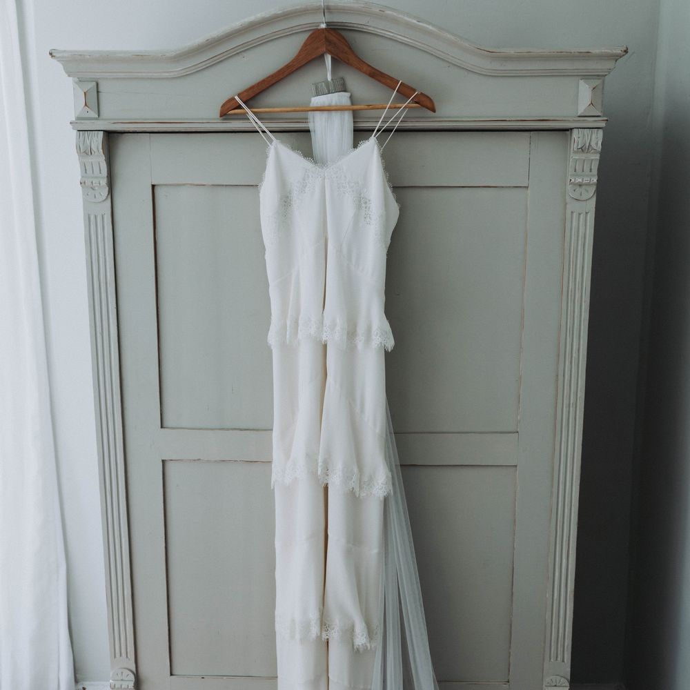 Wedding gown from Whistles hangs on coat hanger before wedding ceremony