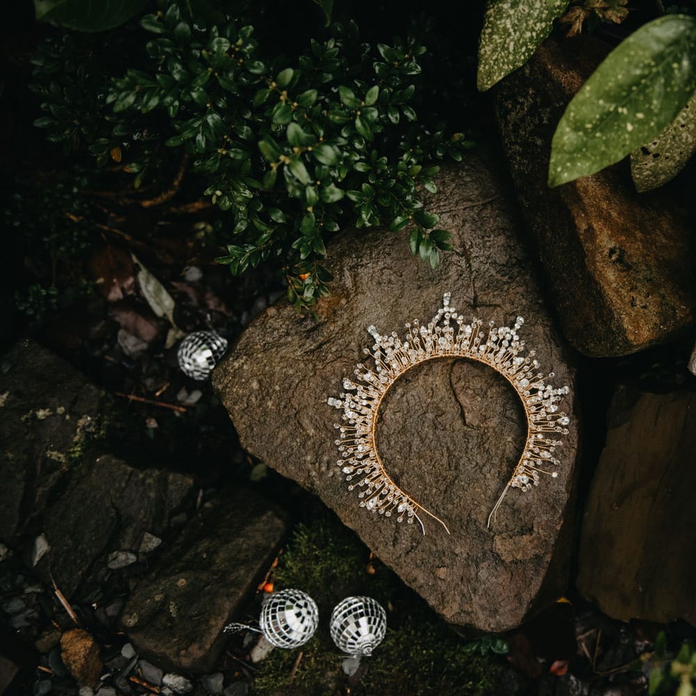 Bejewelled wedding headpiece and disco ball earrings laid outside for Wellbeing Farm wedding 